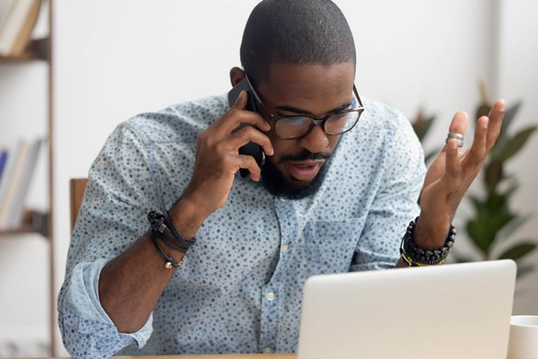 A person talking on the phone while looking at a computer
AI-generated content may be incorrect.
